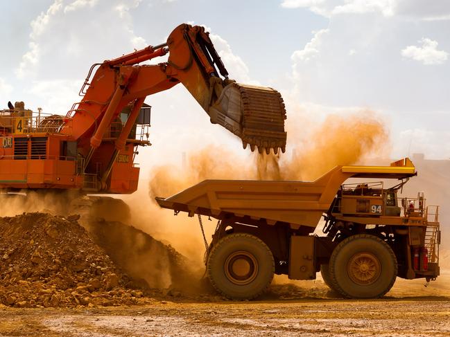 A haul truck is loaded by a digger with material from the pit at Rio Tinto Group's West Angelas iron ore mine in Pilbara, Australia, on Sunday, Feb. 19, 2012. Rio Tinto Group, the world's second-biggest iron ore exporter, will spend $518 million on the first driverless long-distance trains to haul the commodity from its Western Australia mines to ports, boosting efficiency. Photographer: Ian Waldie/Bloomberg via Getty Images