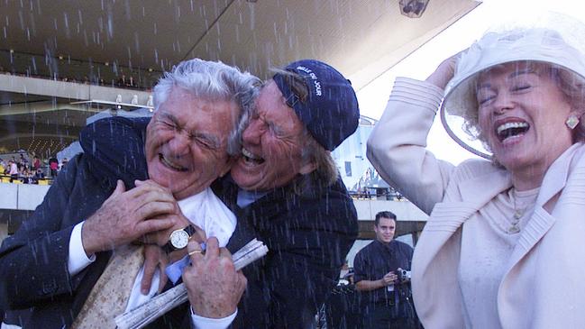 Former Prime Minister Bob Hawke being hugged by businessman John Singleton with Bob's wife Blanche D'Alpuget (right) after their racehorse "Belle Du Jour" won Golden Slipper race at Rosehill in April 2000.