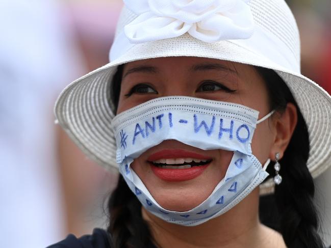 A woman wears a face mask reading "ANTI-WHO" during a demonstration against the restrictions amid the coronavirus pandemic in Dortmund, western Germany, on August 9, 2020. - According to police, several hundred people participated in a rally against the coronavirus policy in Dortmund on Sunday. (Photo by Ina FASSBENDER / AFP)