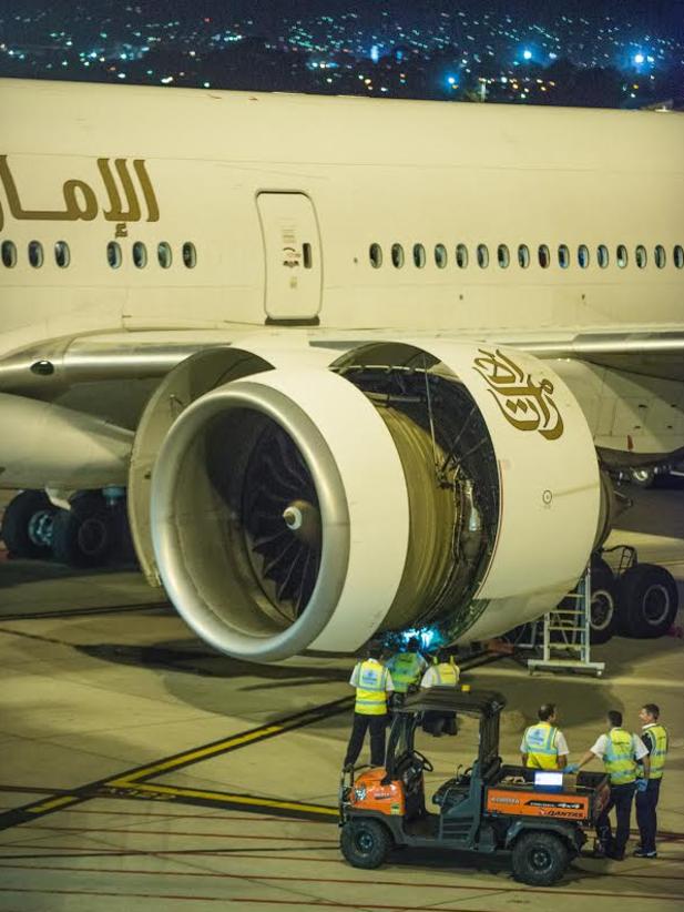 Ground workers inspect the engine of Emirates flight EK432 after the emergency landing. Picture: Warren Bradley