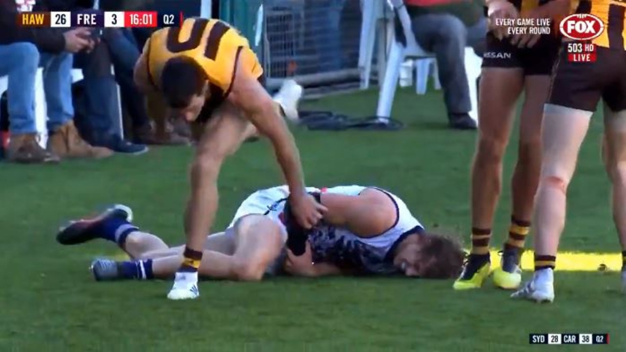 Nat Fyfe grabs at his arm after going down against Hawthorn.