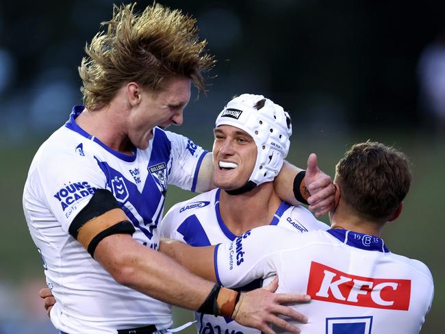 SYDNEY, AUSTRALIA - FEBRUARY 15: Blake Wilson of the Bulldogs celebrates scoring a try with team mates Jacob Preston and Blake Taaffe of the Bulldogs during the NRL Pre-season challenge match between Canterbury Bulldogs and Melbourne Storm at Belmore Sports Ground on February 15, 2024 in Sydney, Australia. (Photo by Brendon Thorne/Getty Images)