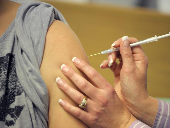 28 year-old Tara Seaton, an Australia Post employee, looks away as Luiza Duszynski, a nursing supervisor at the Royal Adelaide Hospital, injects her with CSL Ltd.'s H1N1 vaccine in Adelaide, Australia, on Wednesday, July 22, 2009. The first human trials of a swine-flu vaccine began today in Australia as deaths and infections from the H1N1 virus mount worldwide, intensifying demand for a protective shot. Photographer: Carla Gottgens/Bloomberg