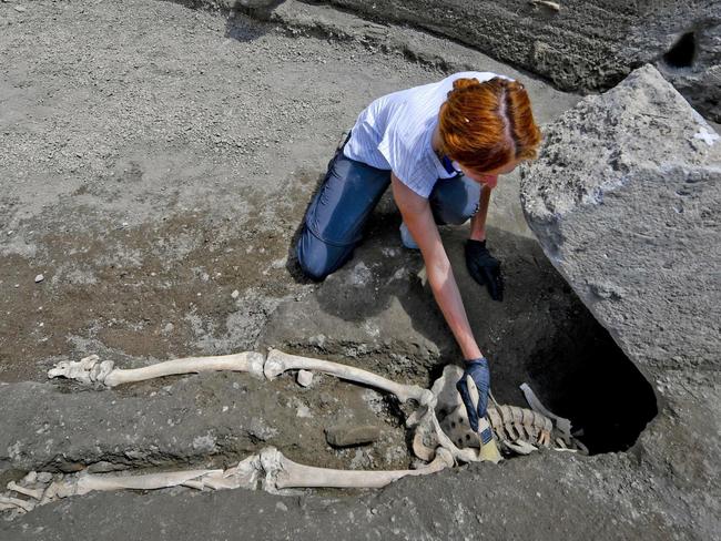 Anthropologist Valeria Amoretti works with a brush on a skeleton of a victim of the eruption of Mt. Vesuvius in A.D. 79, which destroyed the ancient town of Pompeii, at Pompeii' archeological site, near Naples, on Tuesday, May 29, 2018. The skeleton was found during recent excavations and is believed to be of a 35-year-old man with a limp who was hit by a pyroclastic cloud during the eruption. (Ciro Fusco/ANSA via AP)