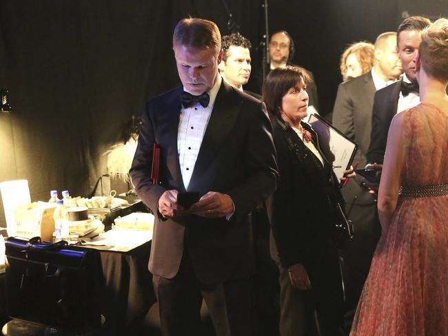 PricewaterhouseCoopers accountant Brian Cullinan holds red envelopes under his arm while using his cell phone backstage at the Oscars at the Dolby Theatre in Los Angeles. Picture: AP