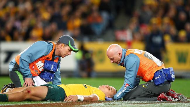 Matt Toomua of the Wallabies receives attention from trainers during the Bledisloe Cup match.