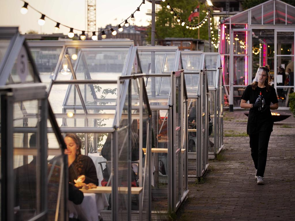 A waitress wearing a protective face shield serves people having dinner in a so-called quarantine greenhouses in Amsterdam. Picture: Robin van Lonkhuijsen/ANP/AFP