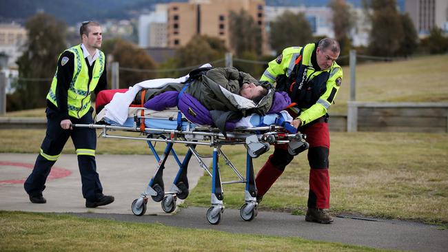 John Ward leaves the Westpac helicopter on a stretcher after arriving back safety in Hobart this afternoon. Pictures: RICHARD JUPE