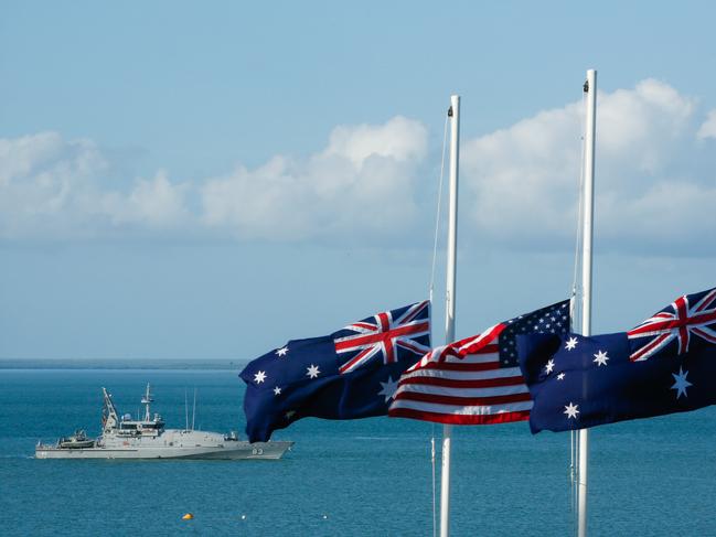 HMAS Armidale marks the spot where the USS Peary was sunk on February 19 1942, while flags fly at half mast during the 77th Anniversary of the Bombing of Darwin special commemorative service in Darwin, Tuesday, February 19, 2019. (AAP Image/GLENN CAMPBELL)
