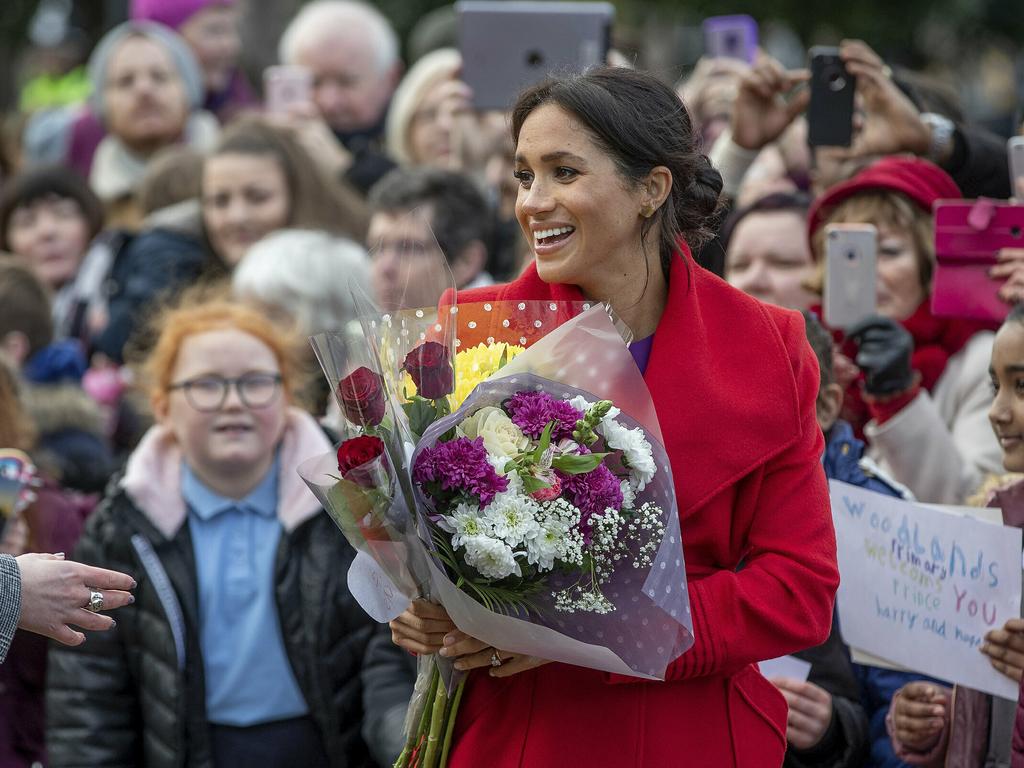 Meghan received flowers from the crowd. Picture: Charlotte Graham/AP