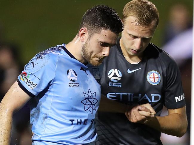 Sydney FC defender Ben Warland is helped from the field by Melbourne City’s Ritchie De Laet on Sunday. Picture: Getty Images 