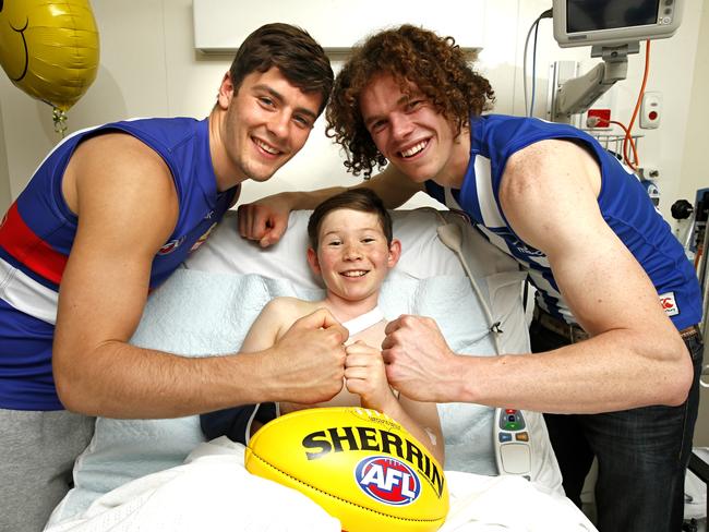 Western Bulldog Josh Dunkley and Kangaroo Ben Brown with Jordan, 10, who is in the Royal Children’s Hospital after getting injured in a motorcycle accident. Picture: David Caird