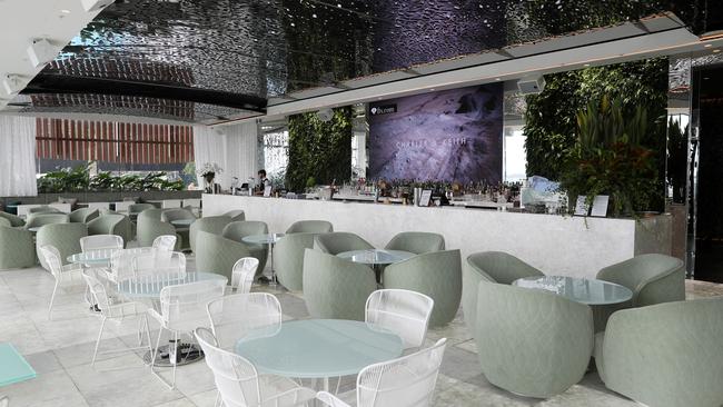 Inside, it’s an elegant mash-up of a dramatic silver filigree-lined retractable roof, white backlit onyx tiles on the floor and along the 13m bar, which is backed by an enormous television screen.