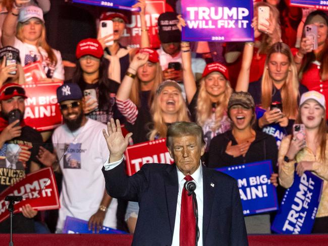 (FILES) Former US President and Republican presidential candidate Donald Trump waves at supporters during a campaign rally at First Horizon Coliseum in Greensboro, North Carolina, on November 2, 2024. Buckle up: Donald Trump returns to the White House next week for a second term that promises to be even more volatile -- and hard-line -- than his roller-coaster first presidency. Buoyed by his historic political comeback, the billionaire Republican has shown no sign of changing the bombastic style that shook the United States and the world from 2017 to 2021. (Photo by CHRISTIAN MONTERROSA / AFP)