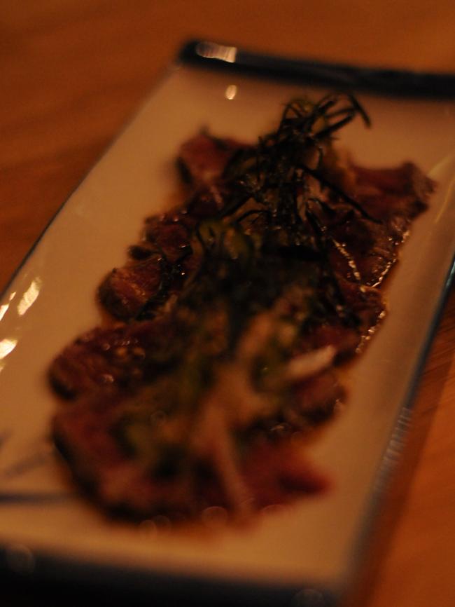 Seared beef fillet tataki with garlic chips, pickled ginger and radish.