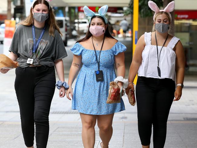 BRISBANE, AUSTRALIA - APRIL 01: City workers (L to R) Hannah Borthwick, Celina Fitt and Maddison Ellis walk through the Brisbane CBD, prior to a three-day lockdown easing on April 01, 2021 in Brisbane, Australia. The Greater Brisbane lockdown will be lifted from 12pm today after a snap three-day lockdown which came into effect at 5 pm on Monday. (Photo by Jono Searle/Getty Images)