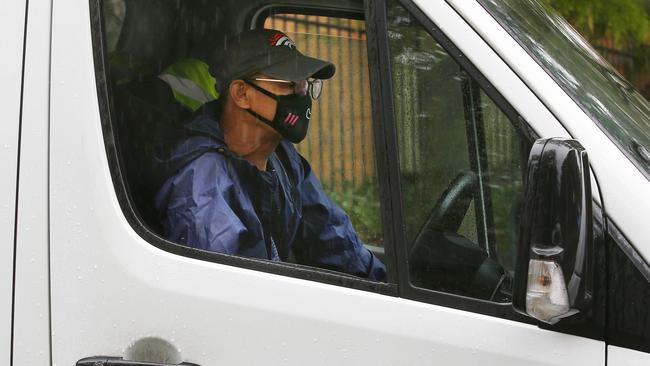 A masked courier leaves the Baptist Care Macquarie Park complex. Picture: John Appleyard