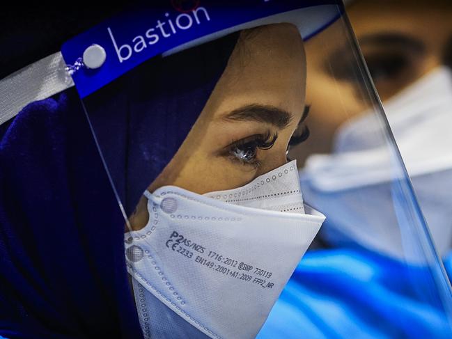 SYDNEY, AUSTRALIA - DECEMBER 23: Health workers look on at the Histopath pre-departure COVID testing clinic at Sydney International airport on December 23, 2021 in Sydney, Australia. Demand at COVID-19 testing centres across Sydney has increased in the lead up to Christmas as NSW coronavirus case numbers rise. People travelling to Queensland, Tasmania and South Australia are required to show a negative PCR test to enter those states while Western Australia's borders are closed to NSW travellers. (Photo by Jenny Evans/Getty Images)