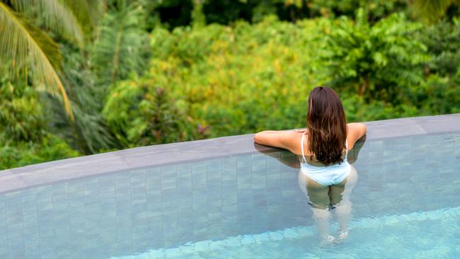 ESCAPE:  Beautiful woman relaxing on her vacations in the swimming pool and looking at the view  Picture: Istock