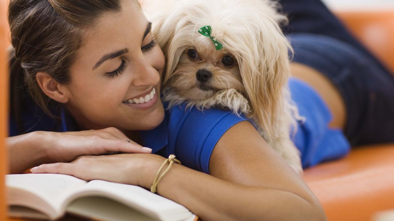 Woman relaxing with a dog in her home.