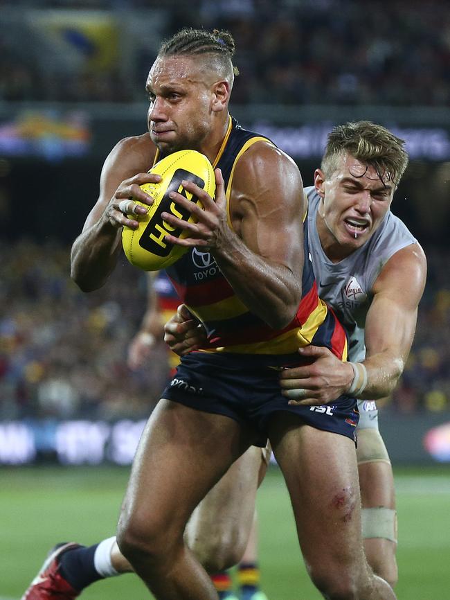 Cameron Ellis-Yolmen tries to break a Patrick Cripps tackle. Picture SARAH REED