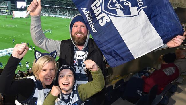 Supporters waving a Geelong Cats flag.