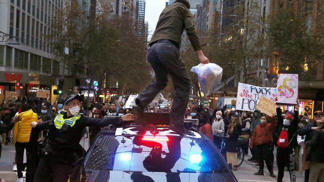 A protester on the roof of a police car. Picture: Wayne Ludbey