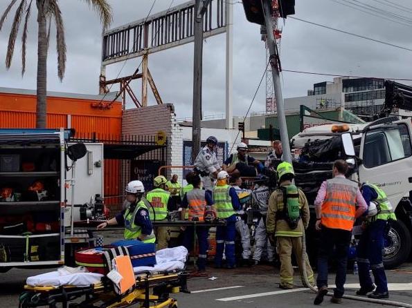 Emergency personnel work to free the trapped driver.