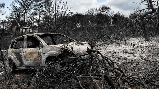 The wreckage of a car in a burnt property of the seaside resort of Mati, Athens. Picture: LOUISA GOULIAMAKI