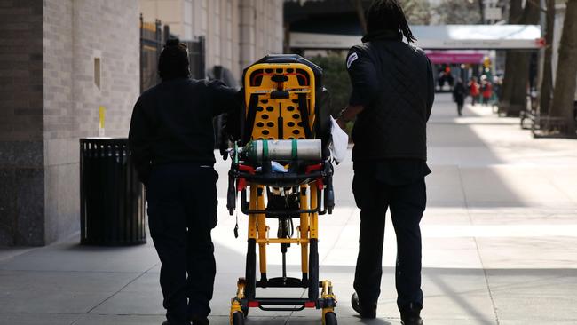 Ambulance drivers walk with a gurney outside of New York’s Mount Sinai Hospital which has seen an upsurge of coronavirus patients. Picture: Spencer Platt/Getty Images/AFP