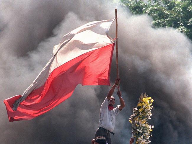 An Indonesian demonstrator holds a huge Indonesian flag in fire and smoke to rally his colleagues during violent clashes between protesting civilians and security forces in Jakarta. Six student protesters died 12 May and at least one died in clashes 13 May between security forces and demonstrators calling for Indonesian President Suharto to step down and take responsibility for the economic crisis.  AFP  PHOTO/CHO Sung-Su. 13 May 1998./Indonesia       /riots