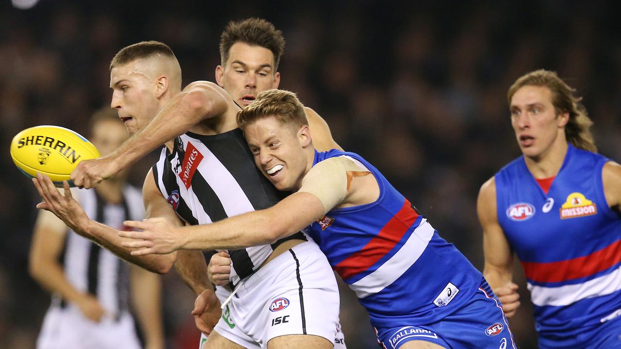 Brayden Sier clears by hand as he is tackled by Lachie Hunter on Sunday.