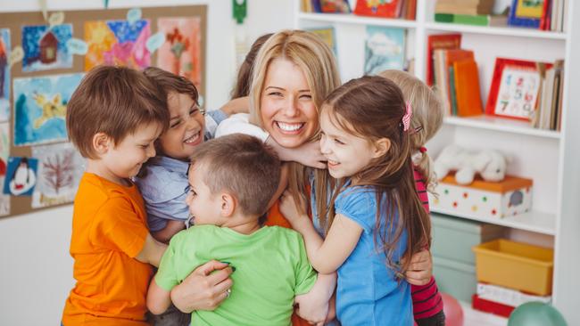 GCS - My Life - Day One Early Learning Centres.Kids in kindergarden playing with their teacher.They are hugging her to express their love.