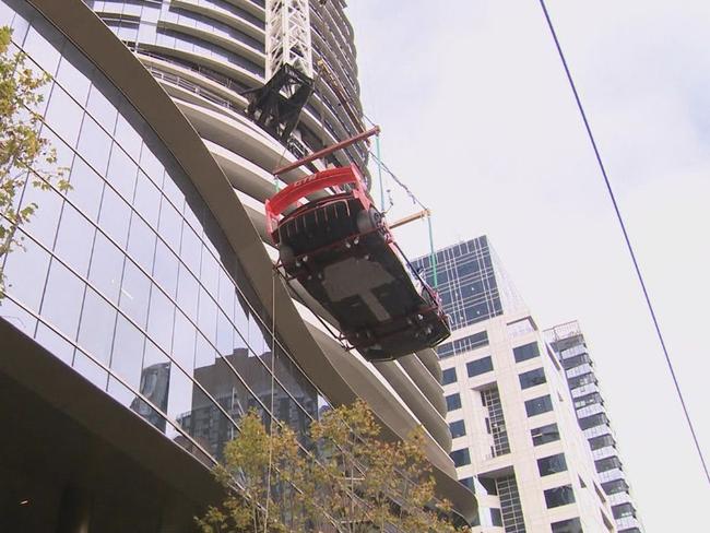 The collectable car was lifted 57 levels to the top of the Sapphire by the Gardens building on Exhibition Street.