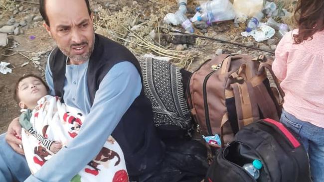 Jawid holding 20-month-old son Hamza, inside Kabul's Hamid Karzai International Airport.