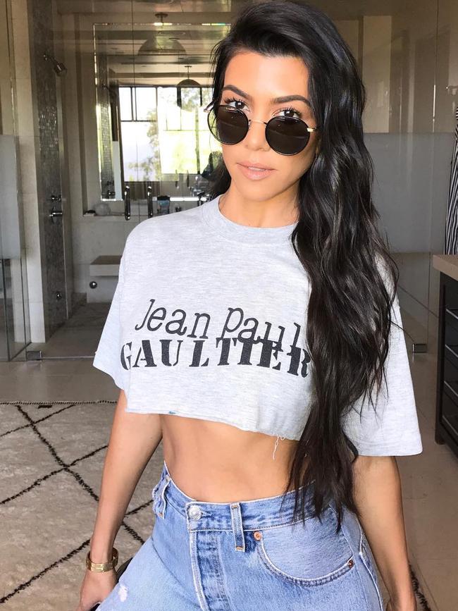 Wearing what looks like her daughters t-shirt, Kourtney Kardashian shows off her abs... 
