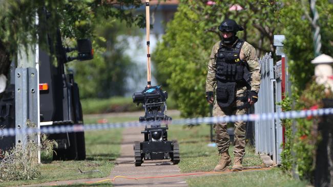 A special ops officer walking his bomb diffusing robot on a suburban footpath in Inala during the bad old days. Pictures: Jack Tran / The Courier Mail