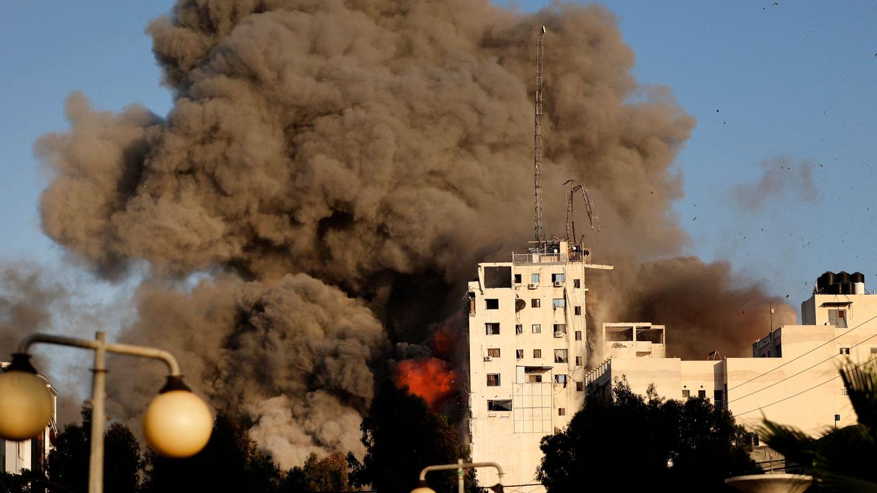 Heavy smoke and fire rise from Al-Sharouk tower as it collapses after being hit by an Israeli air strike, in Gaza City, on May 12. Picture: Mohammed Abed/AFP