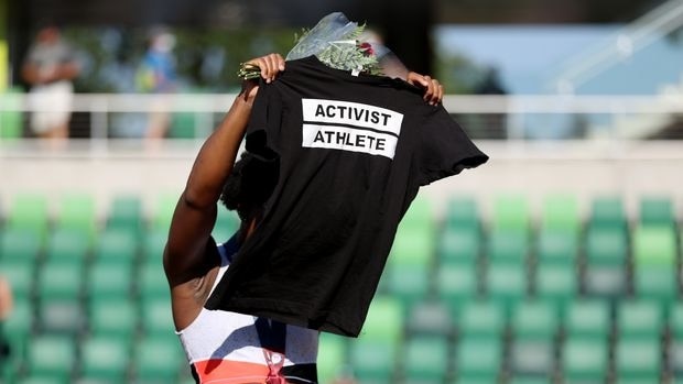 Gwen Berry displays a T-shirt while the US national anthem is played.