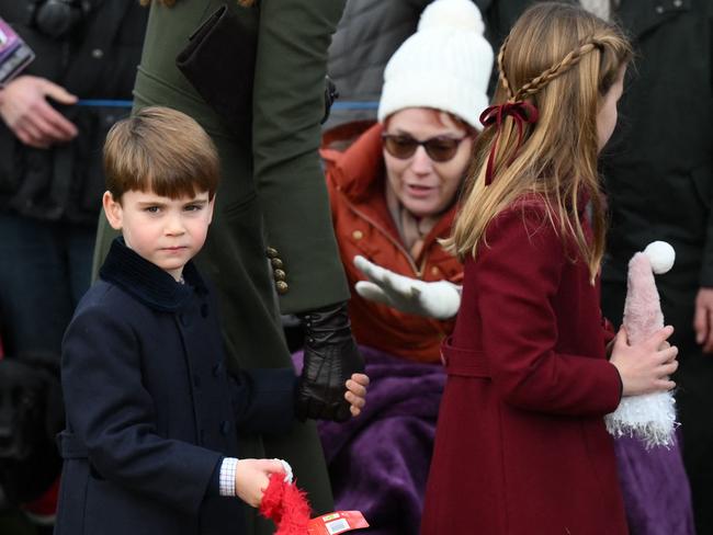 Prince Louis of Wales (L) and Princess Charlotte of Wales are greeted by members of the public as they leave at the end of the Royal Family's traditional Christmas Day service. Picture: AFP