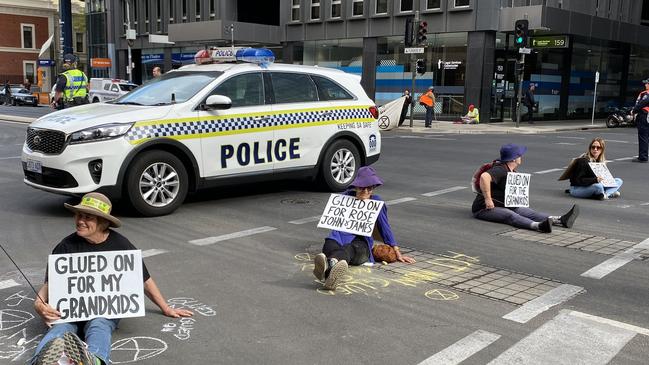 The protesters glued themselves to the road outside the Santos building, forcing police to block off the street and causing significant traffic delays across the city. Picture: Patrick James