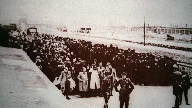 Jewish people lined up by German soldiers at Auschwitz camp after being unloaded from a train.