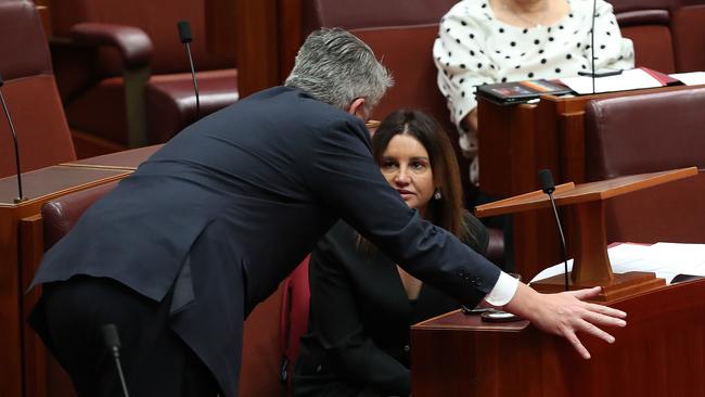 Senator Mathias Cormann talks with Senator Jacqui Lambie in the Senate Chamber at Parliament House in Canberra. Picture: Kym Smith