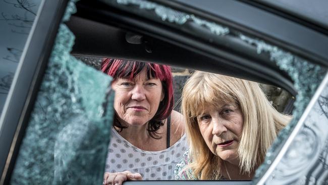 Schoolteachers Leigh Mahady, 62, and Julie Dougherty, 60, look through the smashed window of the car Leigh was driving during the incident. Picture Jake Nowakowski