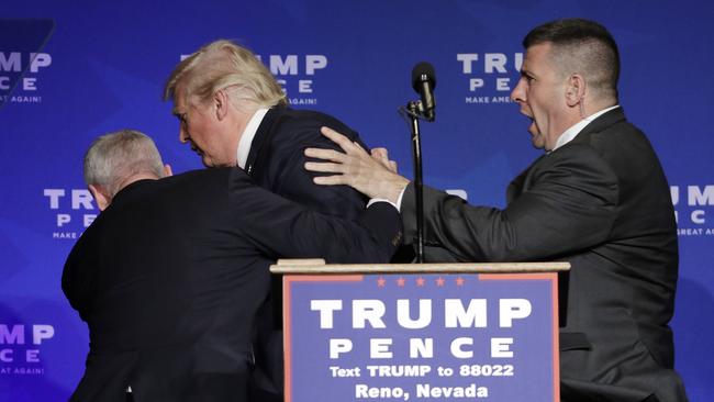 Two Secret Service agents hustle Donald Trump off stage during a misunderstanding in Nevada. Picture: AP