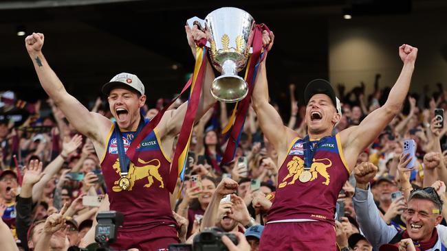 MELBOURNE , AUSTRALIA. September 28, 2024. AFL Grand Final between the Brisbane Lions and Sydney Swans at the MCG. Brisbane Lions players co-captain Lachie Neale and Dayne Zorko hold the Premiership Cup and celebrate with supporters.  Picture: David Caird