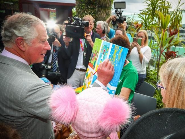 Prince Charles adds his finishing touch to a children’s painting at Lady Cilento Children’s Hospital in Brisbane. Picture: Patrick Hamilton/AFP