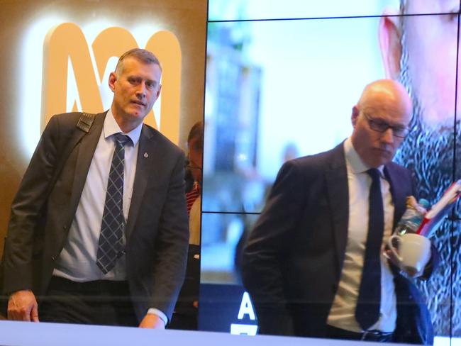 An AFP officer (left) follows ABC News executive editor John Lyons out the main entrance to the ABC building in Ultimo during the raid last year. Picture: David Gray/AAP