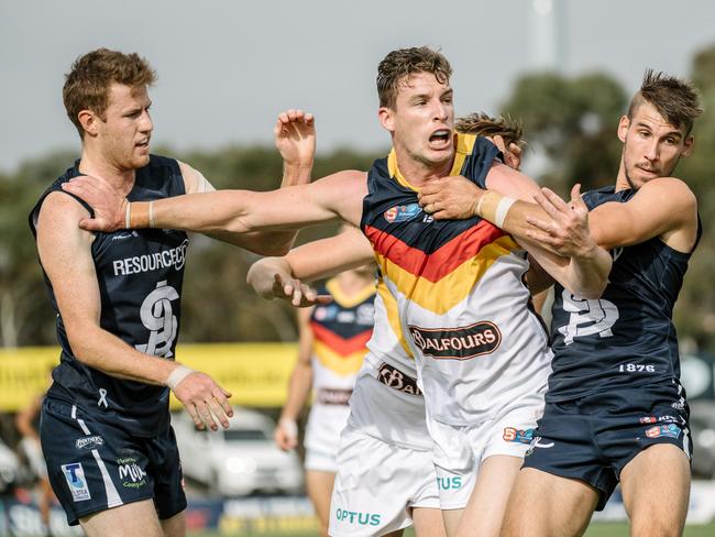 Adelaide player Josh Jenkins with South players Benjamin Haren and Tyson Brown during the South Adelaide versus Adelaide at Noarlunga Oval on Saturday, April 20, 2019. (AAP Image/ Morgan Sette)