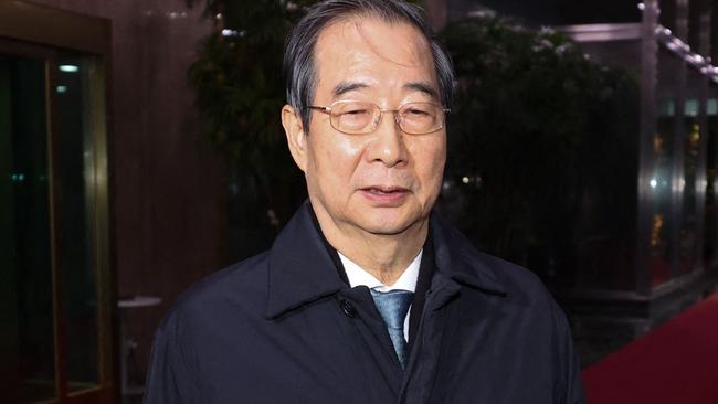 TOPSHOT - South Korea's Prime Minister Han Duck-soo speaks to reporters as he leaves the Government Complex in Seoul on December 27, 2024, after his impeachment motion was passed by the National Assembly. South Korean lawmakers impeached the acting president on December 27, as the country struggles to shake off political turmoil sparked by his predecessor's martial law declaration that shocked the world. (Photo by YONHAP / AFP) / - South Korea OUT / NO ARCHIVES -  RESTRICTED TO SUBSCRIPTION USE